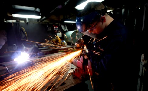 US Navy 120107-N-OY799-055 Hull Maintenance Technician Fireman Apprentice Mitchell Myrstol, left, welds a bracket while Hull Maintenance Technician