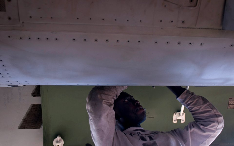 US Navy 120107-N-TZ605-095 Aviation Electronics Technician 2nd Class Attah Anoh, assigned to Strike Fighter Squadron (VFA) 81, performs maintenance
