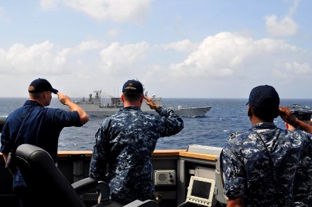 US Navy 120203-N-ZZ999-096 Ensign Christopher Veenhuis, left, Cmdr. Justin Kubu, Lt.j.g. Georges Banks and Lt. Rick Zabawa render honors aboard the