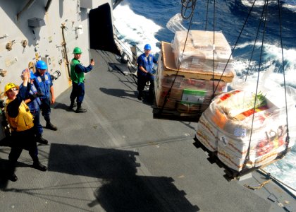 US Navy 120102-N-ZF681-539 Boatswain's Mate 2nd Class Jason Connole, assigned the guided-missile destroyer USS Halsey (DDG 97) guides pallets of su