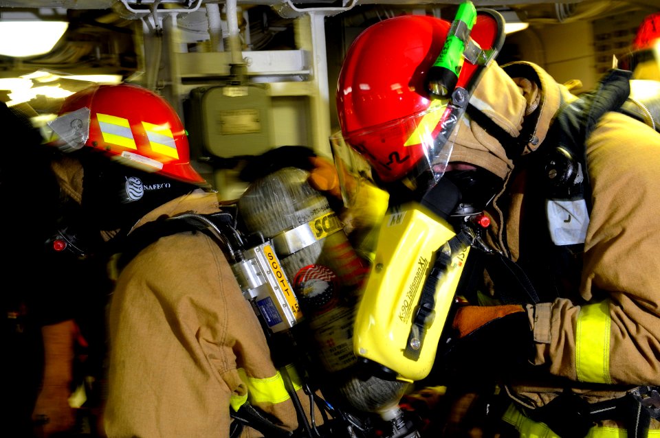 US Navy 120106-N-RG587-048 Damage Controlman 2nd Class Jared Olah, a hose team leader assigned to the ship's flying squad, looks through the Navy f
