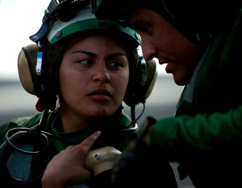 US Navy 120105-N-DR144-268 Aviation Boatswain's Mate (Equipment) Airman Tiffany Romero speaks to another Sailor aboard the Nimitz-class aircraft ca
