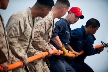 US Navy 120105-N-PB383-979 A Sailor demonstrates how to properly handle a hose during a damage control training exercise photo