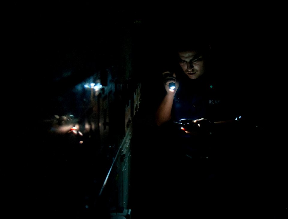 US Navy 120110-N-DR144-402 Electrician's Mate 3rd Class Juan Murillo eports the status of an electrical load center during a loss of power drill
