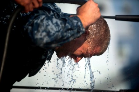 US Navy 120105-N-PB383-541 A Sailor pours water on his face after being sprayed with oleoresin capsicum