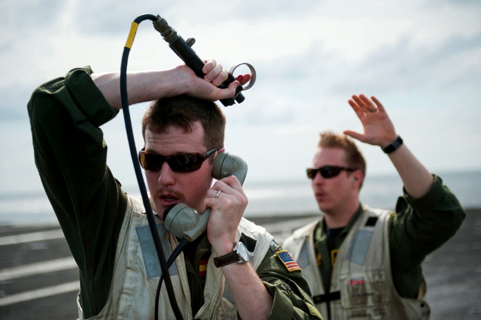 US Navy 120105-N-DR144-010 Landing Signal Officer Lt. John Harrington, assigned to Carrier Airborne Early Warning Squadron (VAW) 125, makes sure th