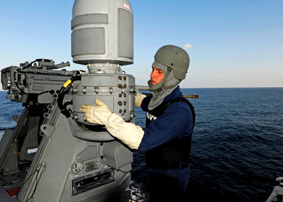 US Navy 120103-N-VH839-239 Gunner's Mate 3rd Class Patrick Dean performs a maintenance check on an MK 38 MOD 2 25mm machine gun system