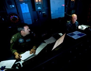 US Navy 120107-N-MD252-180 Lt. Brian Snook, left, and Cmdr. David Schlesinger discuss flag operations in the tactical flag command center aboard th