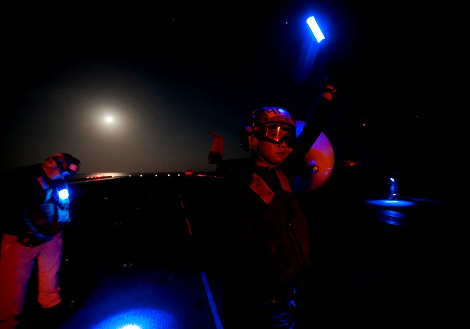 US Navy 120111-N-DR144-054 Aviation Structural Mechanic Airman Telstar Pinaroc, assigned to Strike Fighter Squadron (VFA) 25, signals that an F-A-1