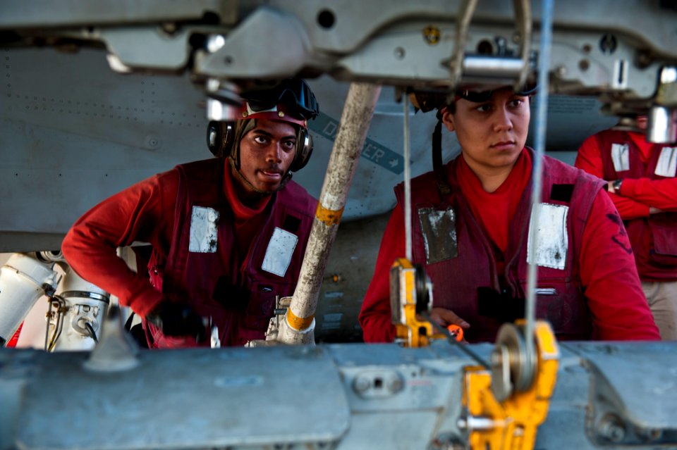 US Navy 120112-N-BT887-010 Aviation Ordnanceman Airman James Caise cranks an ordnance-loading hoist aboard the Nimitz-class aircraft carrier USS Jo