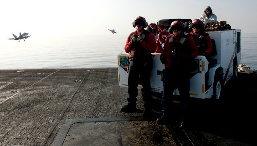 US Navy 120107-N-OY799-188 Sailors stand crash and salvage watch on the bow as two fixed wing aircraft launch off the flight deck of the Nimitz-cla