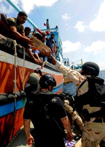 US Navy 120118-N-VH839-032 Sailors from the guided-missile destroyer USS Dewey's (DDG 105) visit, board, search and seizure team provide food, wate photo