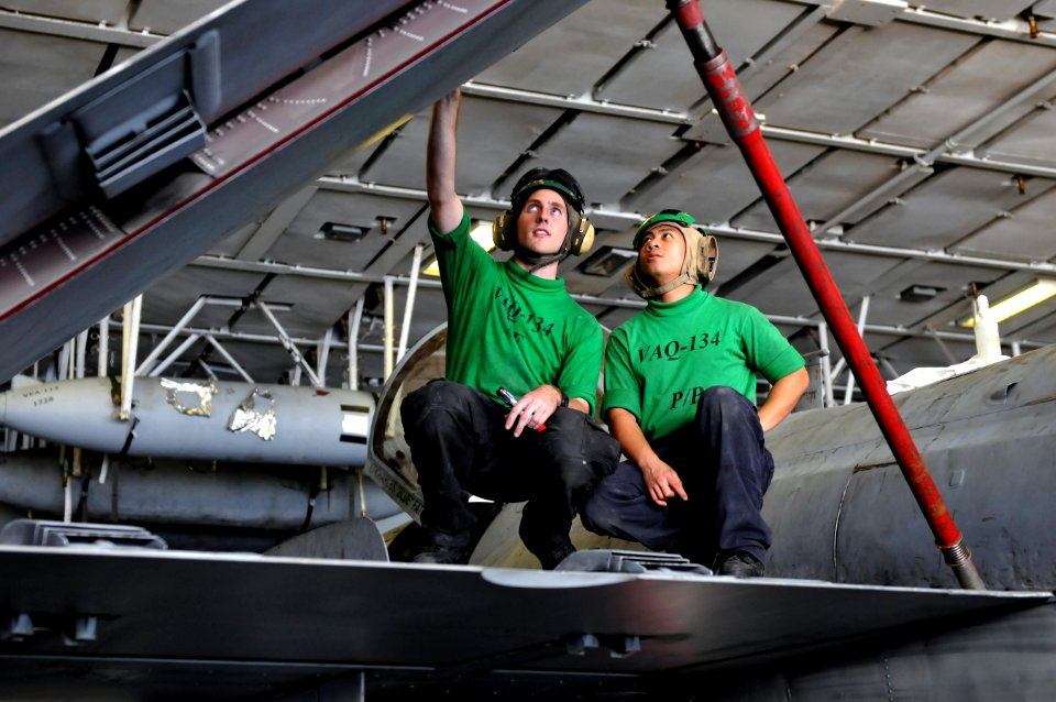 US Navy 120110-N-ZZ999-208 Sailors conduct maintenance on the wing of an EA-6B Prowler in the hangar bay aboard the Nimitz-class aircraft carrier U
