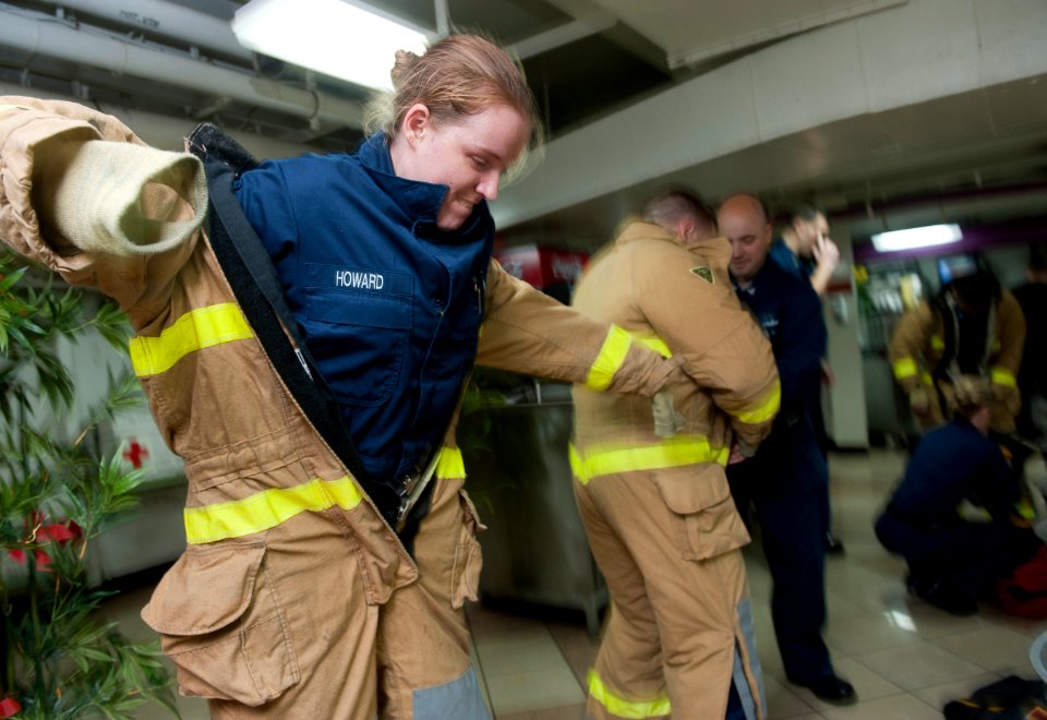 US Navy 120109-N-DR144-024 Machinist's Mate 1st Class Elizabeth Howard dons a firefighting ensemble