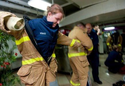 US Navy 120109-N-DR144-024 Machinist's Mate 1st Class Elizabeth Howard dons a firefighting ensemble
