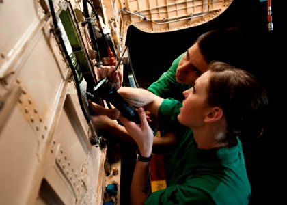 US Navy 120106-N-BT887-284 Sailors install a fire bottle into a jet