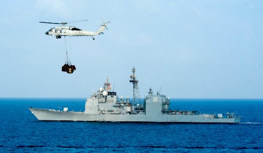 US Navy 120110-N-OY799-137 An MH-60S Sea Hawk from the Eightballers of Helicopter Sea Combat Squadron (HSC) 8 carries pallets past the Ticonderoga