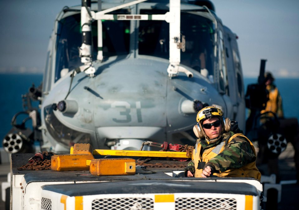 US Navy 120114-N-PB383-018 A Sailor moves a helicopter on the flight deck