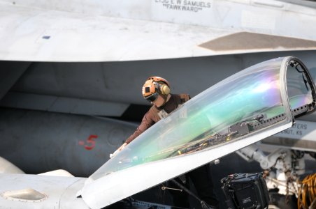US Navy 120111-N-GZ832-336 A plane captain cleans the canopy of an F-A 18C Hornet on the flight deck aboard the Nimitz-class aircraft carrier USS C