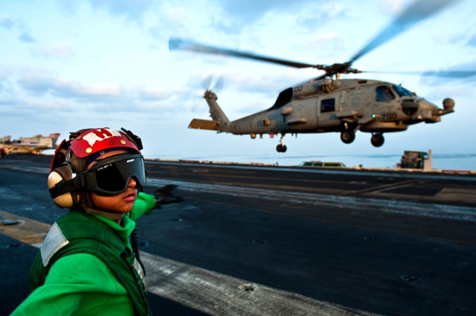 US Navy 120108-N-BT887-007 Airman Joyce Cruz checks for a clear deck before signaling to an MH-60R Seahawk from the Raptors of Helicopter Maritime