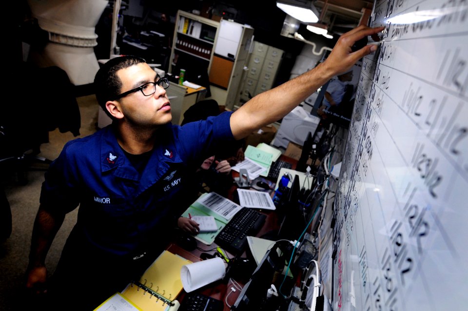US Navy 120112-N-MD252-101 Aviation Maintenance Administrationman 2nd Class Nicholas Minor, updates a jet engine status board in production control
