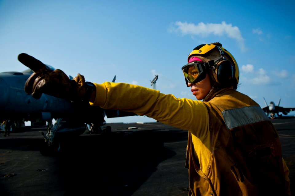 US Navy 120109-N-BT887-025 Aviation Boatswain's Mate (Handling) 3rd Class Adelita Sisporon directs an F-A-18E Super Hornet from the Tophatters of S