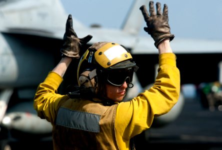 US Navy 120109-N-OY799-064 Aviation Boatswain's Mate (Handling) Airman Michael Linscott directs a fixed-wing aircraft on the flight deck of the Nim