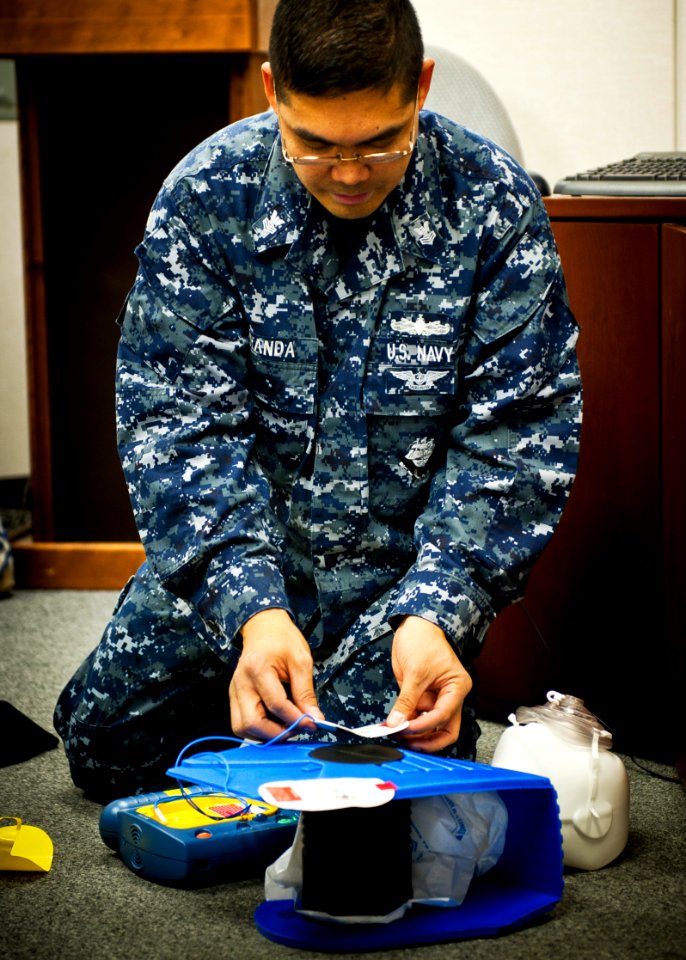 US Navy 120117-N-KK576-025 A Sailor instructs a class on how to properly operate an automated external defibrillator
