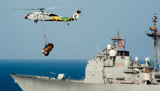 US Navy 120110-N-OY799-183 An MH-60S Sea Hawk from the Eightballers of Helicopter Sea Combat Squadron (HSC) 8 carries pallets past the Ticonderoga