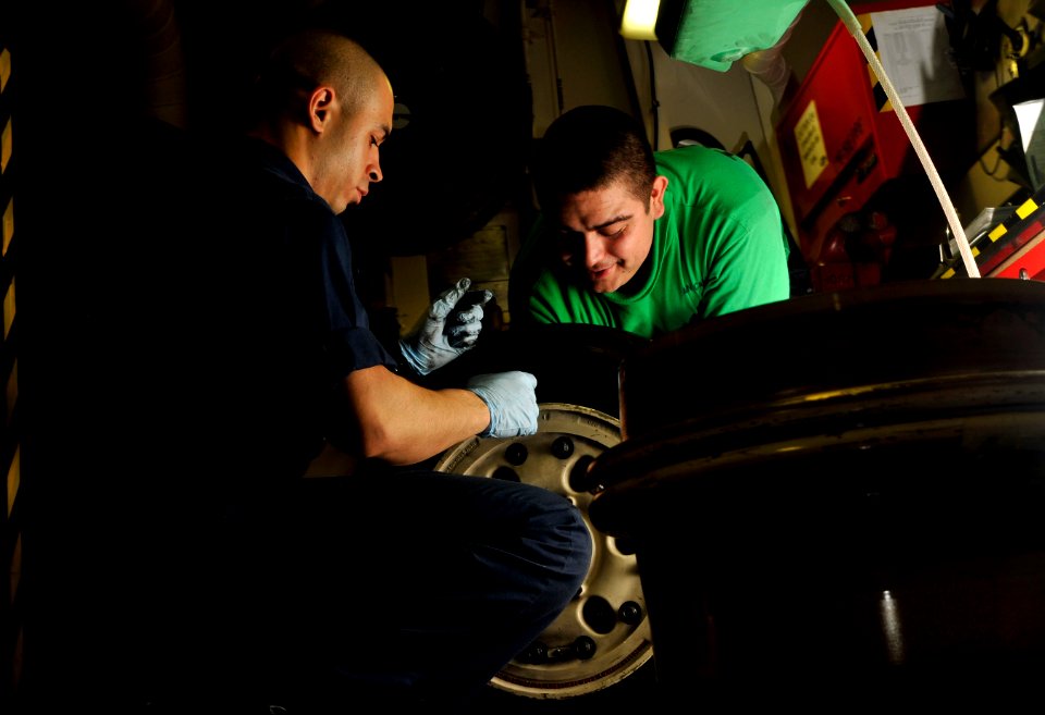 US Navy 120112-N-ZI635-110 Sailors perform maintenance on the tire of an F-A-18 C Hornet