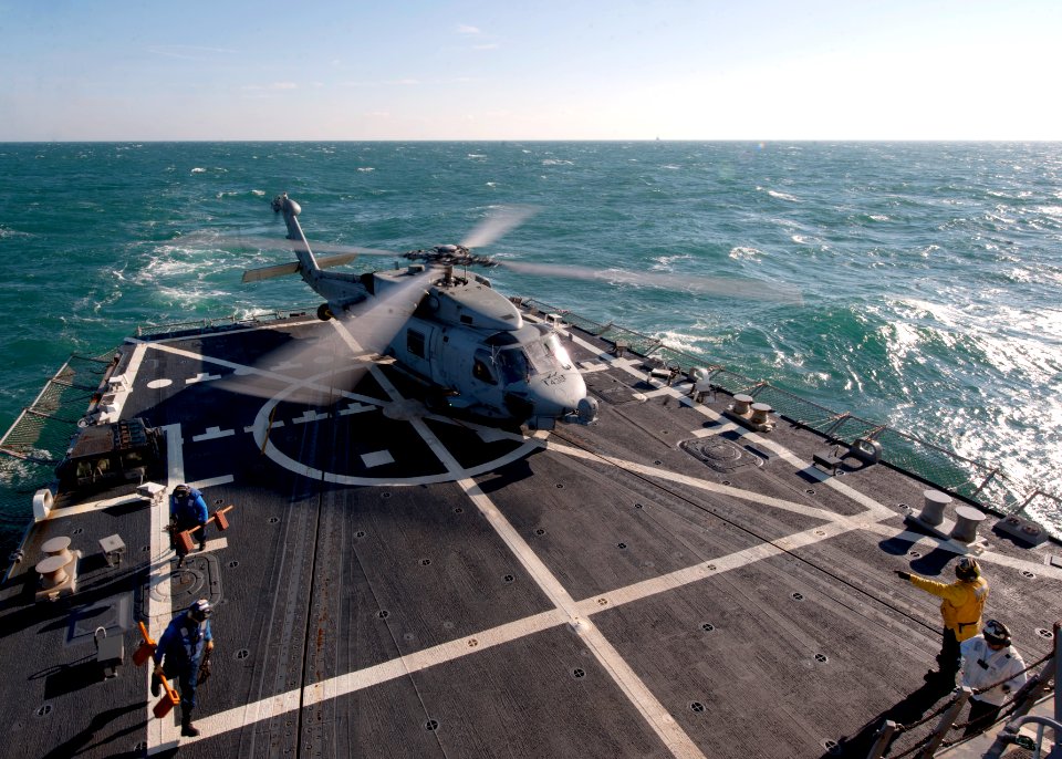 US Navy 120112-N-NL401-049 Flight deck personnel remove chocks and chains from an SH-60B Sea Hawk helicopter assigned to Helicopter Anti-Submarine