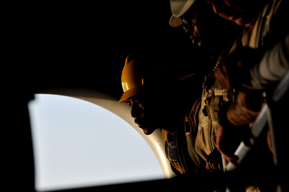 US Navy 120117-N-ZI635-420 Boatswains Mate 1st Class Dustan T. Lowe watches as Sailors man lines to ready a rigid hull inflatable boat during a man