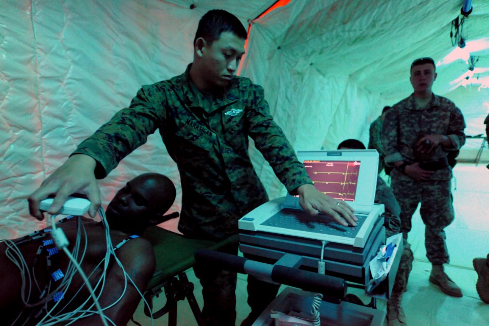 US Navy 120113-N-GO179-026 Hospital Corpsman Glen Marasigan monitors the EKG reading of Logistics Specialist Seaman Wayne Terry, explaining the res