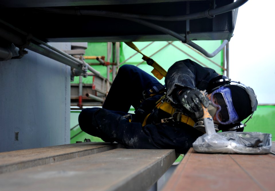 US Navy 120119-N-SF704-030 Electronics Technician 3rd Class Jordan Panlaqui puts more paint on his brush while painting the outside of the aircraft