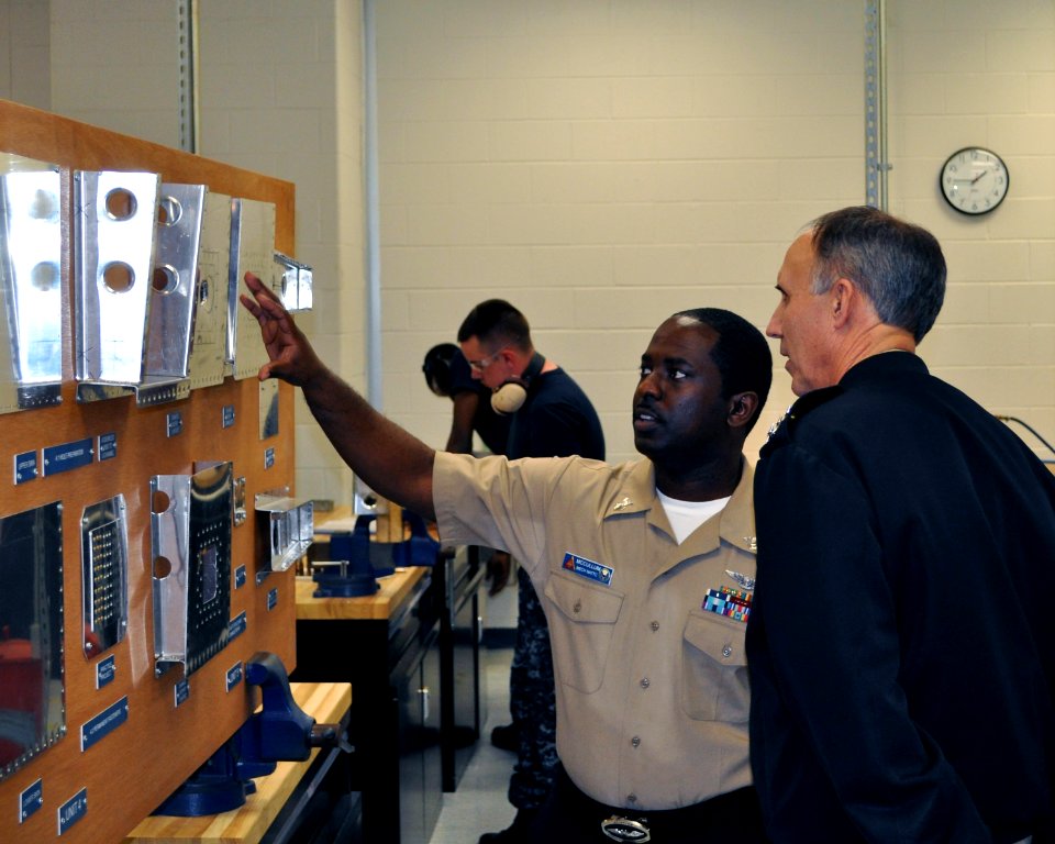 US Navy 120118-N-IM980-006 Aviation Structure Mechanic 1st Class Charles McCullum explains to Vice Adm. Scott Van Buskirk how structural mechanics