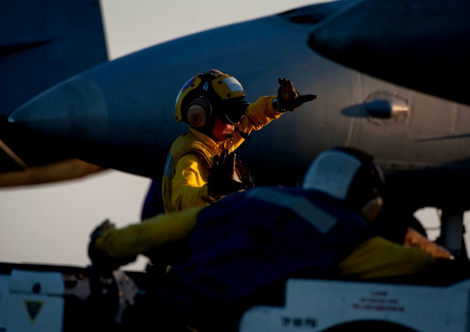 US Navy 120118-N-DR144-322 Aviation Boatswain's Mate (Handling) 3rd Class Alexsis Labrake directs the movement of aircraft on the flight deck aboar