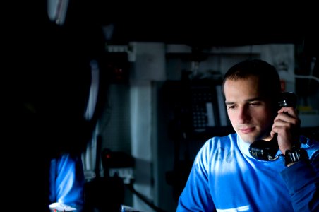 US Navy 120119-N-TZ605-072 Aviation Boatswain's Mate Airman Richard Bloom receives reports of aircraft locations while standing watch in flight dec