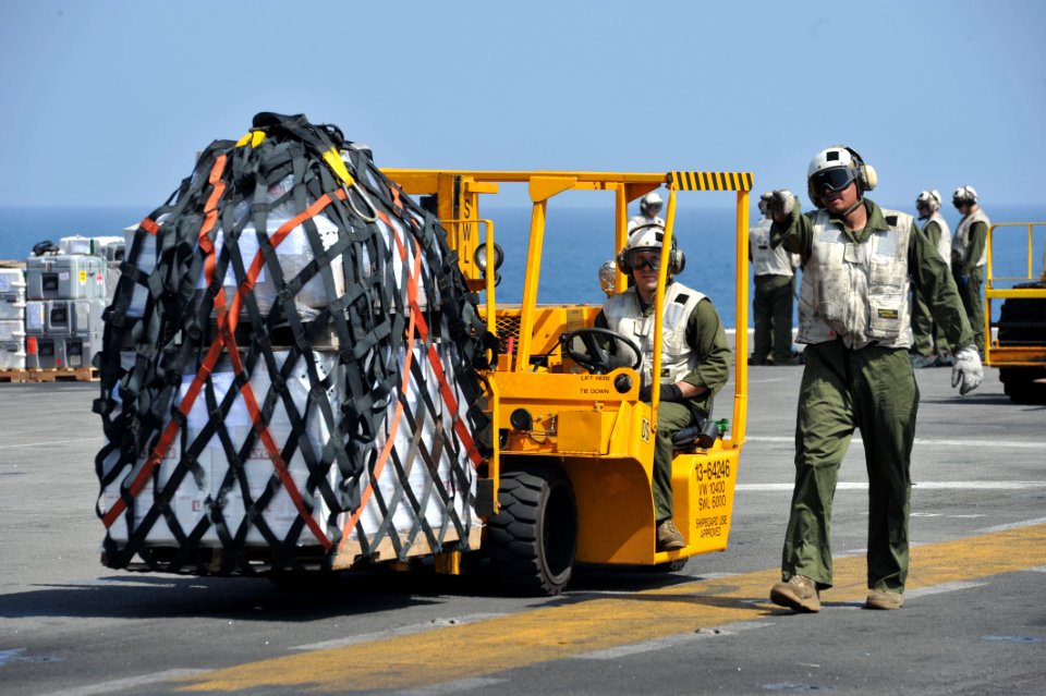 US Navy 120116-N-KD852-039 Marines from Combat Cargo assigned to 11th Marine Expeditionary Unit (11th MEU) move supplies across the flight deck abo