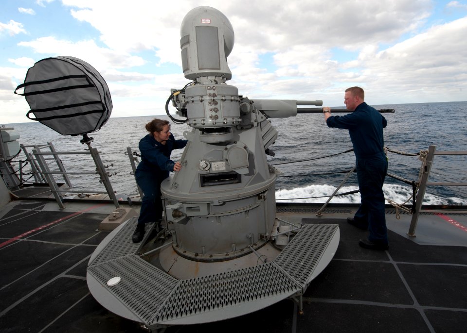 US Navy 120116-N-NL401-079 Gunners Mate 3rd Class Stephanie R. Melton and Gunners Mate Seaman Jeffrey T. James conduct maintenance on the MK38 MOD
