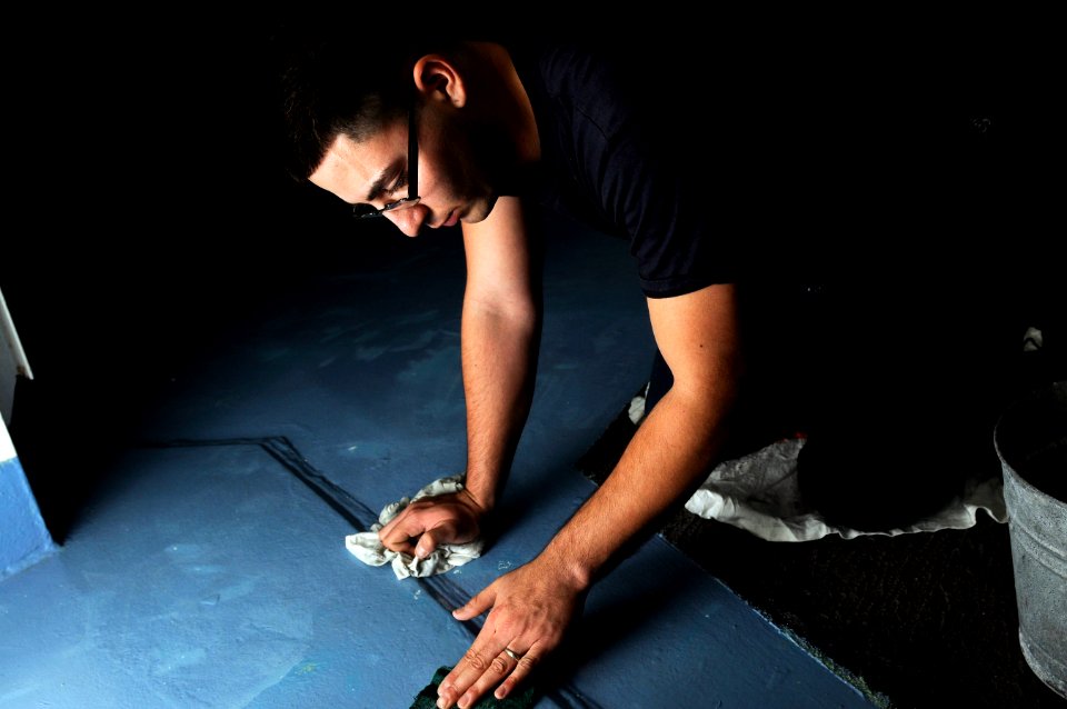 US Navy 120118-N-RG587-315 Seaman Jesus Trevizo scrubs the deck in the forecastle aboard the Nimitz-class aircraft carrier USS Carl Vinson (CVN 70)