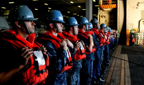 US Navy 120119-N-ZI635-131 Sailors wait to handle lines in the hangar bay aboard the Nimitz-class aircraft carrier USS Carl Vinson (CVN 70) during