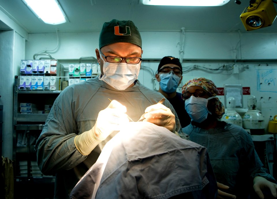 US Navy 120120-N-JN664-002 Lt. Cmdr. Howard Pryor, a Navy doctor, makes an incision into an epidermal inclusion cyst on the head of a patient in th