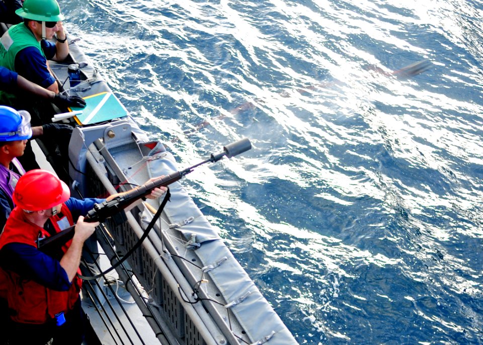 US Navy 120119-N-ZF681-083 Gunner's Mate 2nd Class Erik Trudel, assigned to the guided-missile destroyer USS Halsey (DDG 97), fires a shot line