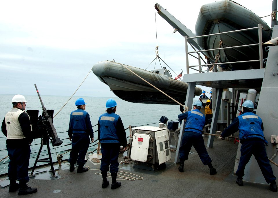 US Navy 120118-N-NL401-020 Sailors lower a rigid-hull inflatable boat to be used during a visit, board, search and seizure exercise aboard the Arle