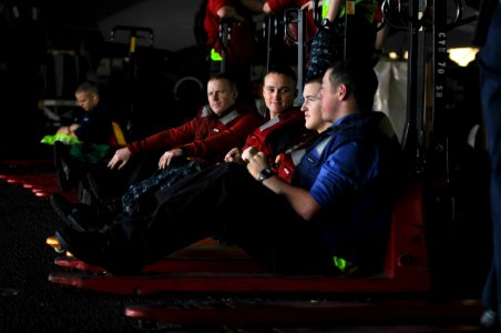 US Navy 120119-N-ZI635-234 Sailors stand by with pallet jacks to move supplies from an aircraft elevator into the hangar bay aboard the Nimitz-clas