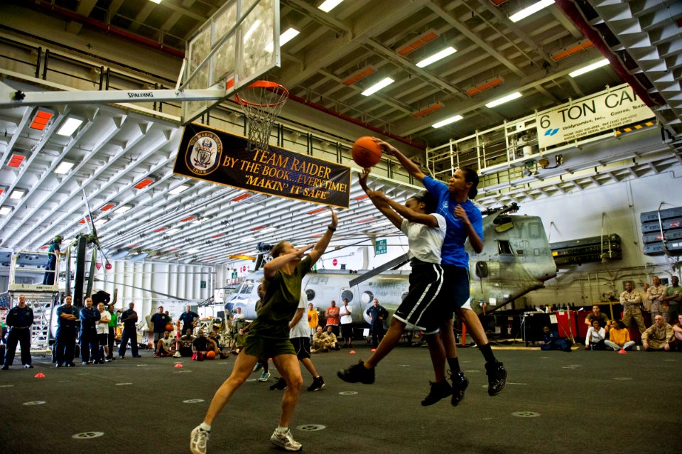 US Navy 120121-N-DX615-138 Operations Specialist 1st Class Lisa Moore blocks a shot during a 3-on-3 basketball tournament aboard the amphibious ass