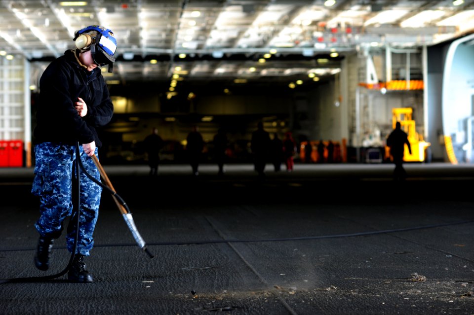 US Navy 120124-N-XE109-014 Aviation Boatswain's Mate Airman Danielle M. Jones cleans the hangar bay of the aircraft carrier USS George H.W. Bush (C