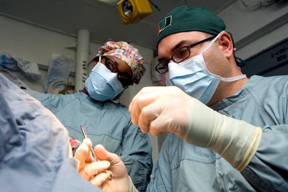 US Navy 120120-N-JN664-004 Lt. Cmdr. Howard Pryor, a Navy doctor, stitches an incision while Hospital Corpsman 3rd Class Destiny Dansby observes in