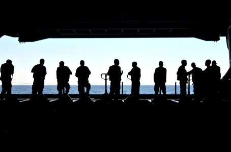 US Navy 120119-N-ZI635-261 Sailors stand by with pallet jacks to move supplies from an aircraft elevator into the hangar bay aboard the Nimitz-clas