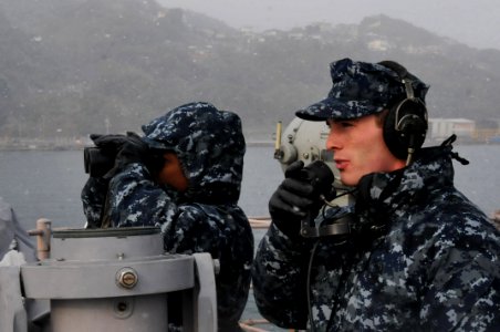 US Navy 120124-N-MU720-091 Culinary Specialist 1st Class Montreon Smith and Mineman Seaman Kyle Walker stand forward lookout watch as the ship depa